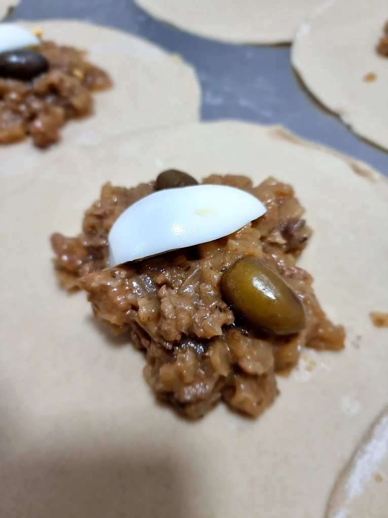 Preparación de empanadas de pino de El Suizo con huevo y aceituna